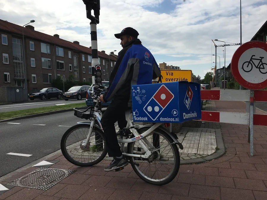 Repartidor en bicicleta eléctrica entregando un pedido
